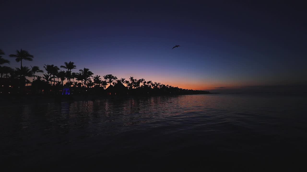 日落时分的热带海滩。浪漫的夜晚，海上的灯火荡漾，4k视频视频素材