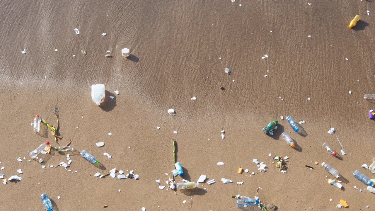 海浪把塑料垃圾推到海滩上视频下载