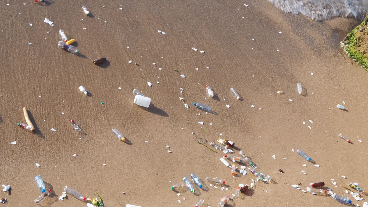 海浪把塑料垃圾推到海滩上视频素材