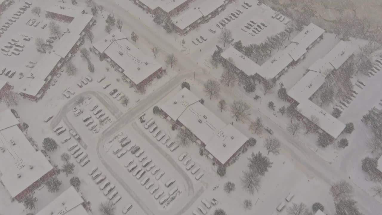 冬天的景色在下雪的日子里，小镇的屋顶房屋与景观街道被雪覆盖视频素材