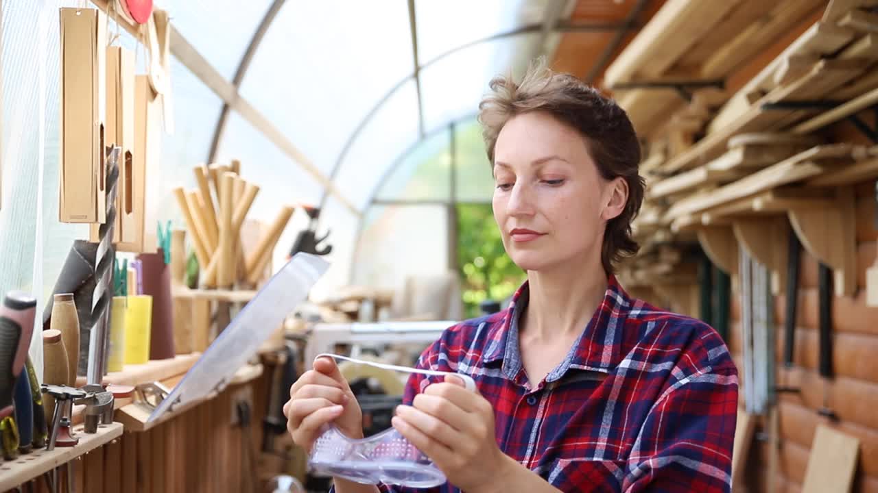 年轻漂亮的手巧的专业快乐的女性强壮的木匠肖像戴着护目镜在木工diy车间工作对木材。视频素材