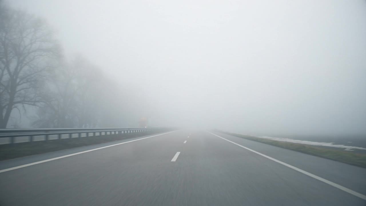 司机POV空灰色多雾多雨的城际公路，能见度低，在寒冷的春天或秋天的早晨。视频下载