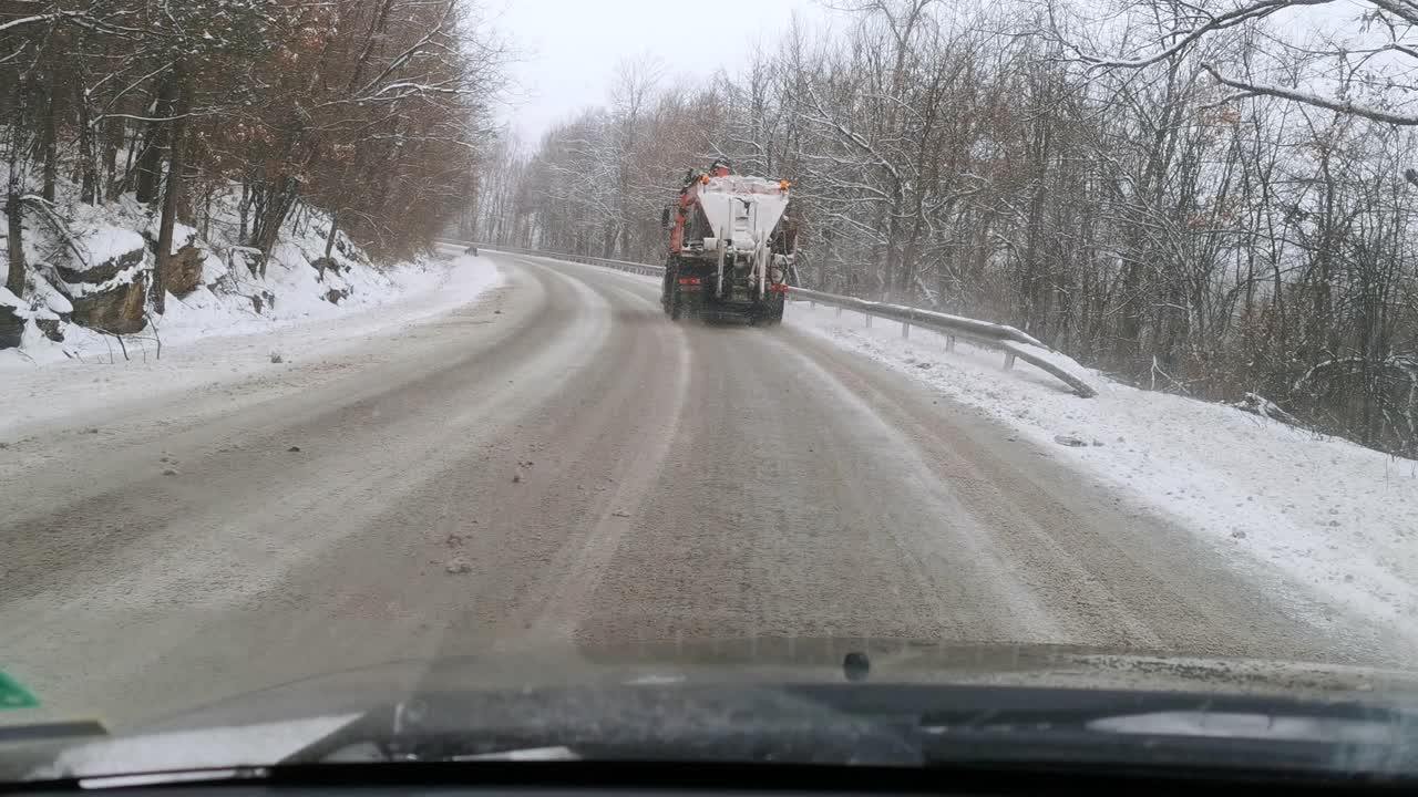 汽车观点。2019冠状病毒病大流行期间，在大雪中开车上班。忙碌的生活中，交通因铲雪机而减速。视频素材