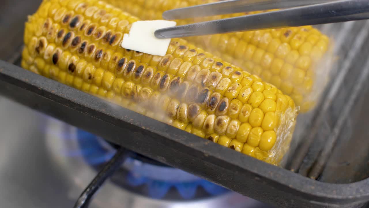热玉米上融化黄油，烤盘上的玉米和黄油，特写，4k视频下载