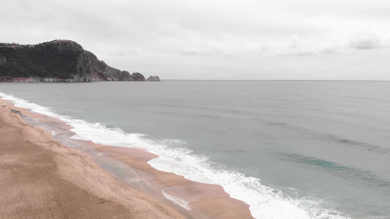 海浪冲击着沙滩。鸟瞰海浪和美丽的海滩。美丽的蓝色海浪拍打着空旷的沙滩视频素材