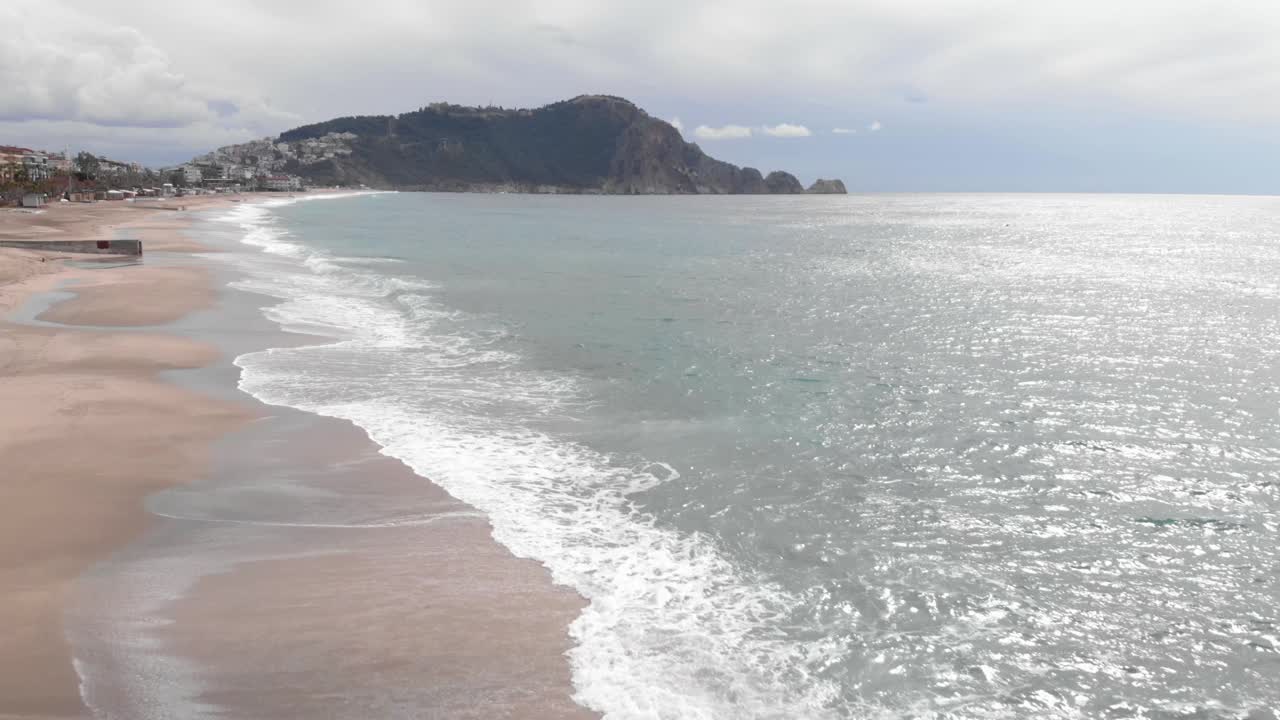 在暴风雨的大风天，海浪带着白色的泡沫。海浪拍打着沙滩。美丽的海上风景视频素材