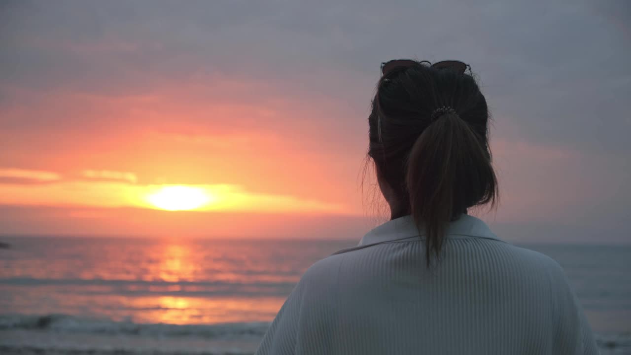 美丽女人的背影看日出思考生活在海洋的观点视频素材