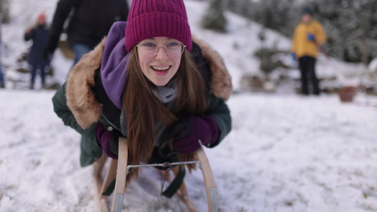 一个十几岁的女孩在后院玩雪橇视频素材