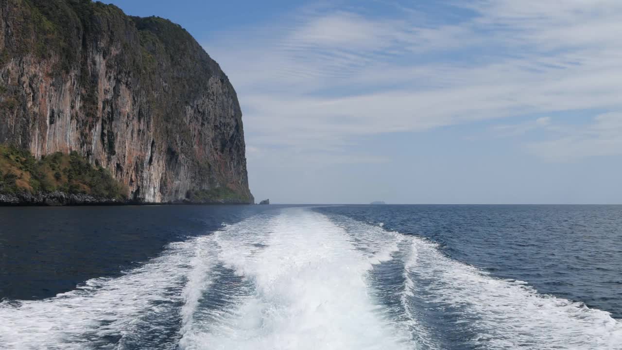 从岛上看船的后部。在海面上，快艇后面的波浪掠过水面视频素材