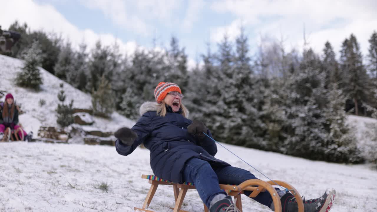 冬天的一天，一位老妇人在后院拉雪橇视频素材