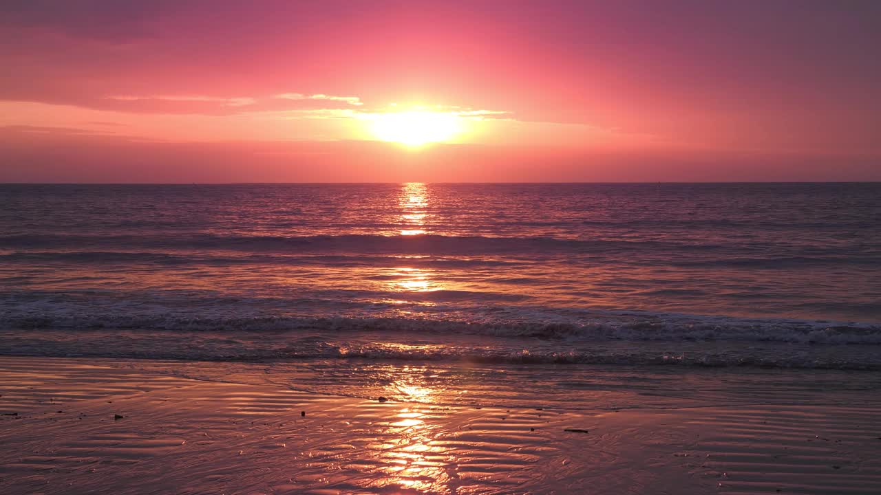 海滩上的天空是红色的夕阳。太阳落到地平线上。玫瑰金色的天空，美妙的自然黄昏天空。视频素材