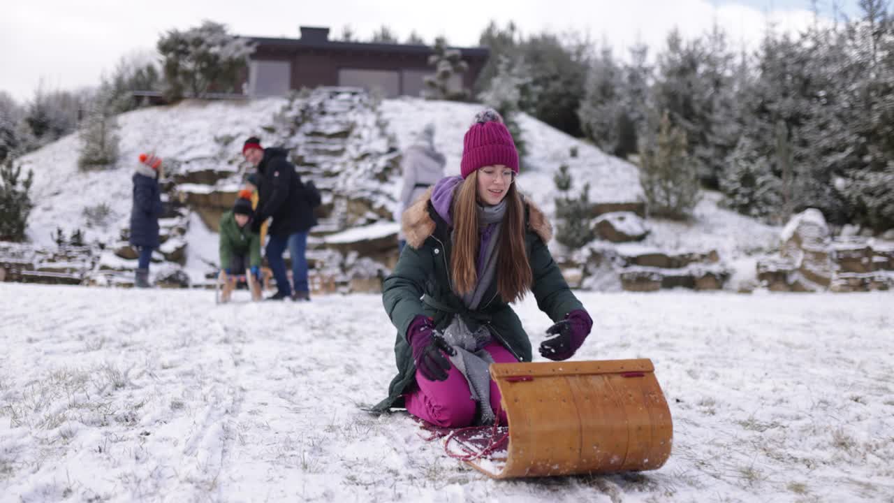 一个十几岁的女孩在后院玩雪橇视频素材