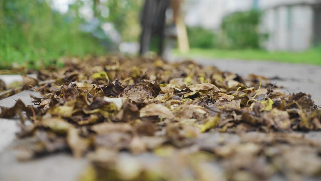 骑自行车的人把轮子踩在干树叶上急刹车。酷酷的慢镜头视频素材