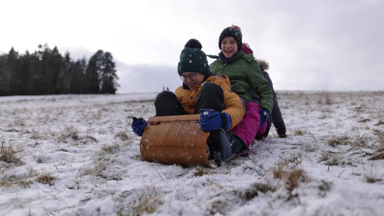 冬天，孩子们一起在山上玩雪橇视频素材