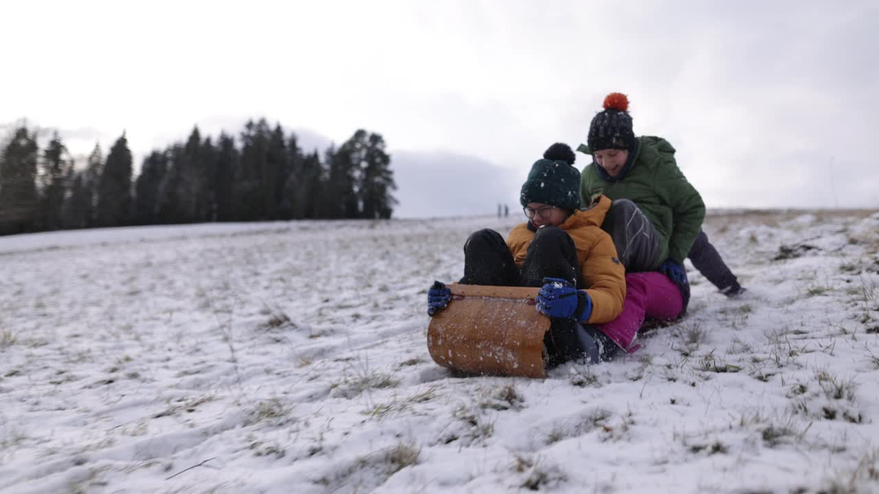 冬天，孩子们一起在山上玩雪橇视频素材