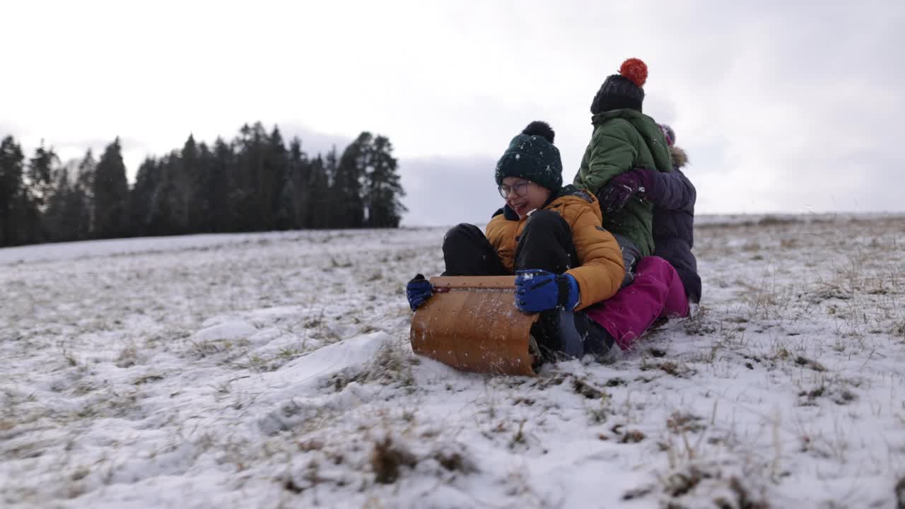 冬天，孩子们一起在山上玩雪橇视频素材