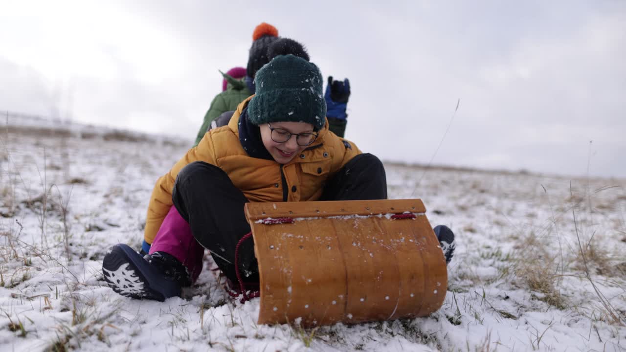 冬天，孩子们一起在山上玩雪橇视频素材