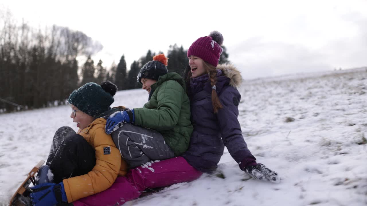 冬天，孩子们一起在山上玩雪橇视频素材