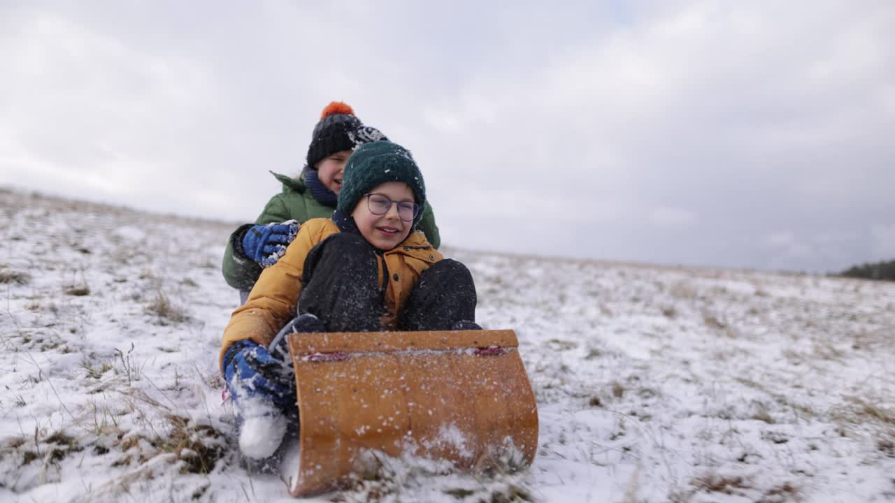 冬天，孩子们一起在山上玩雪橇视频素材