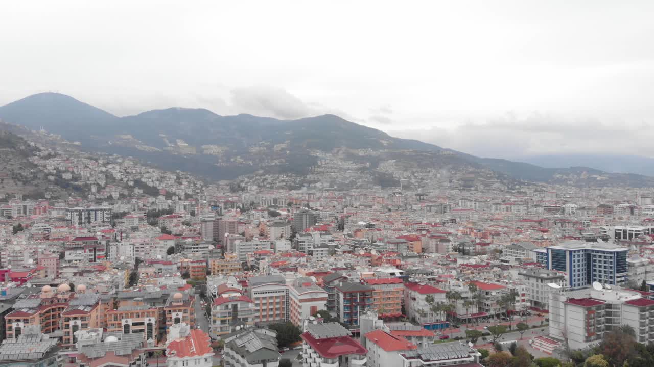 现代城市的住宅建筑和酒店与山的背景，无人机的观点。土耳其旅游度假城市阿兰亚鸟瞰。美丽的景观视频素材