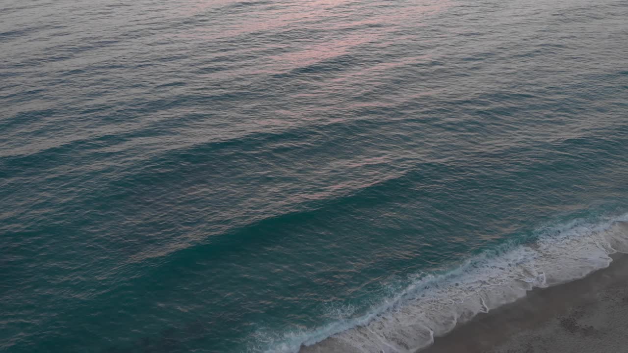 海滩上的夕阳在海面上，阳光反射在水中。粉色海洋日落。夏季热带日落视频素材