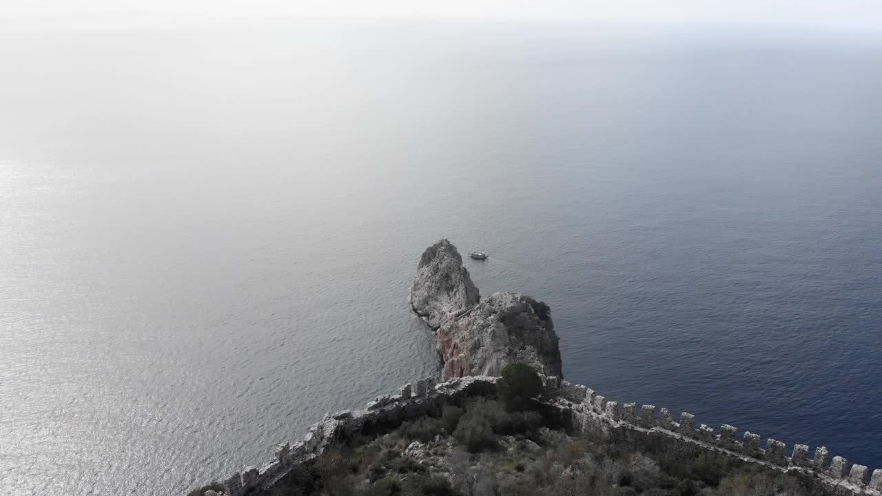 城堡废墟和岩石在海上，鸟瞰。无人驾驶飞机飞过黑海要塞遗址。令人惊叹的自然景观和海景视频素材