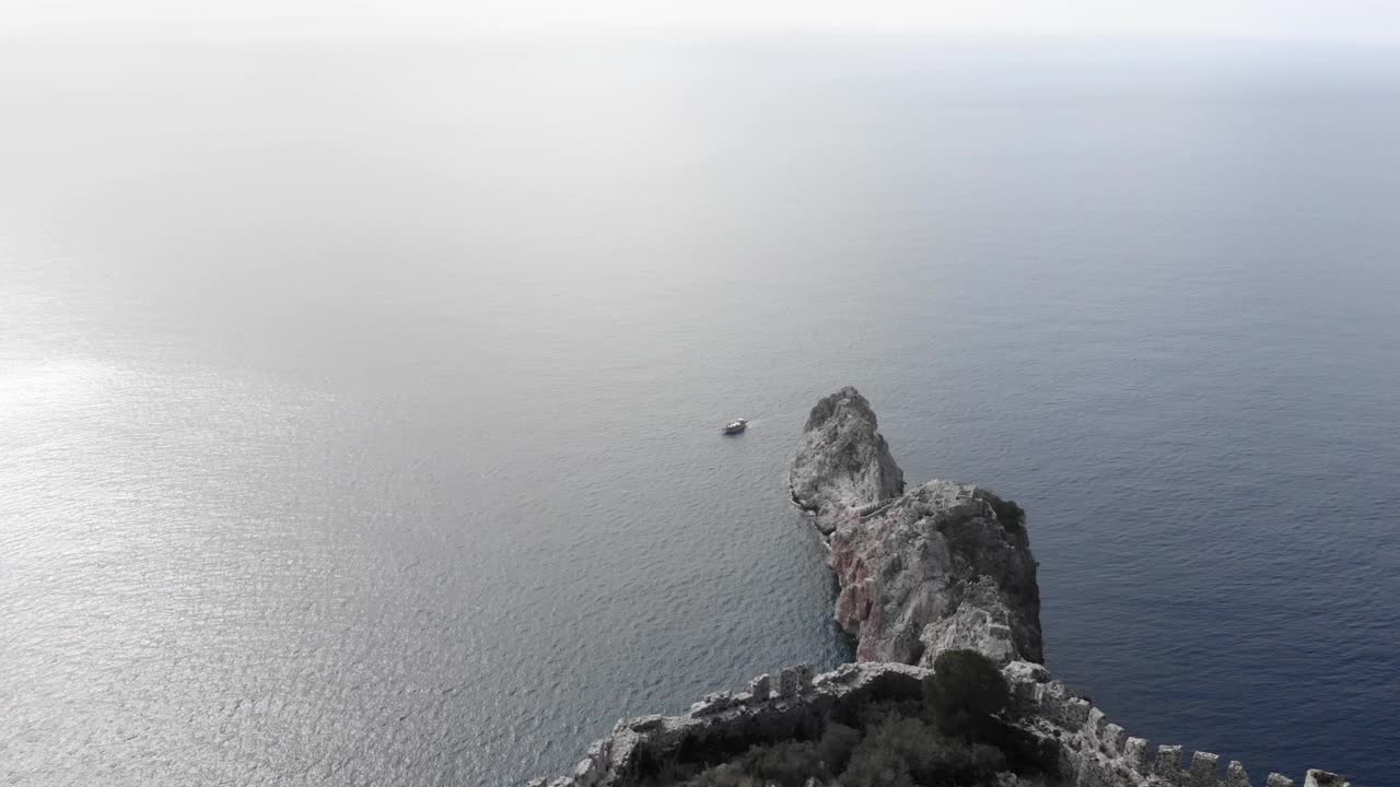 蓝色海洋中的巨大石崖。鸟瞰风平浪静的大海与空石峭壁视频素材