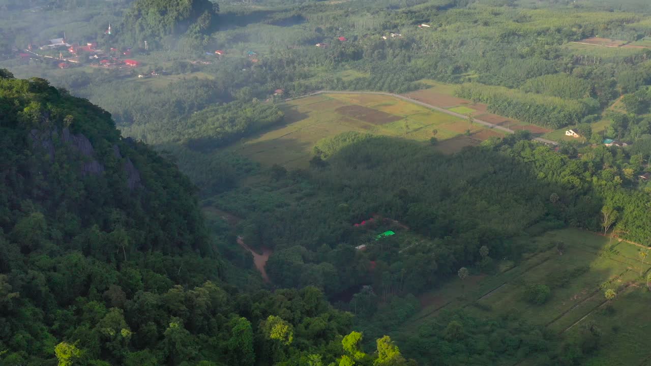 无人机拍摄的泰国松卡古哈山清晨的农田和山景，大雾弥漫视频素材