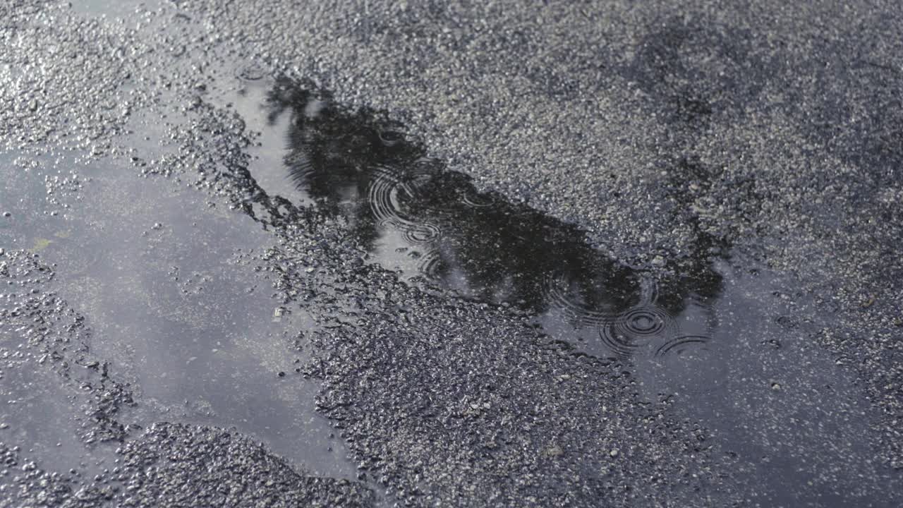 沥青路上的水坑和雨滴视频素材