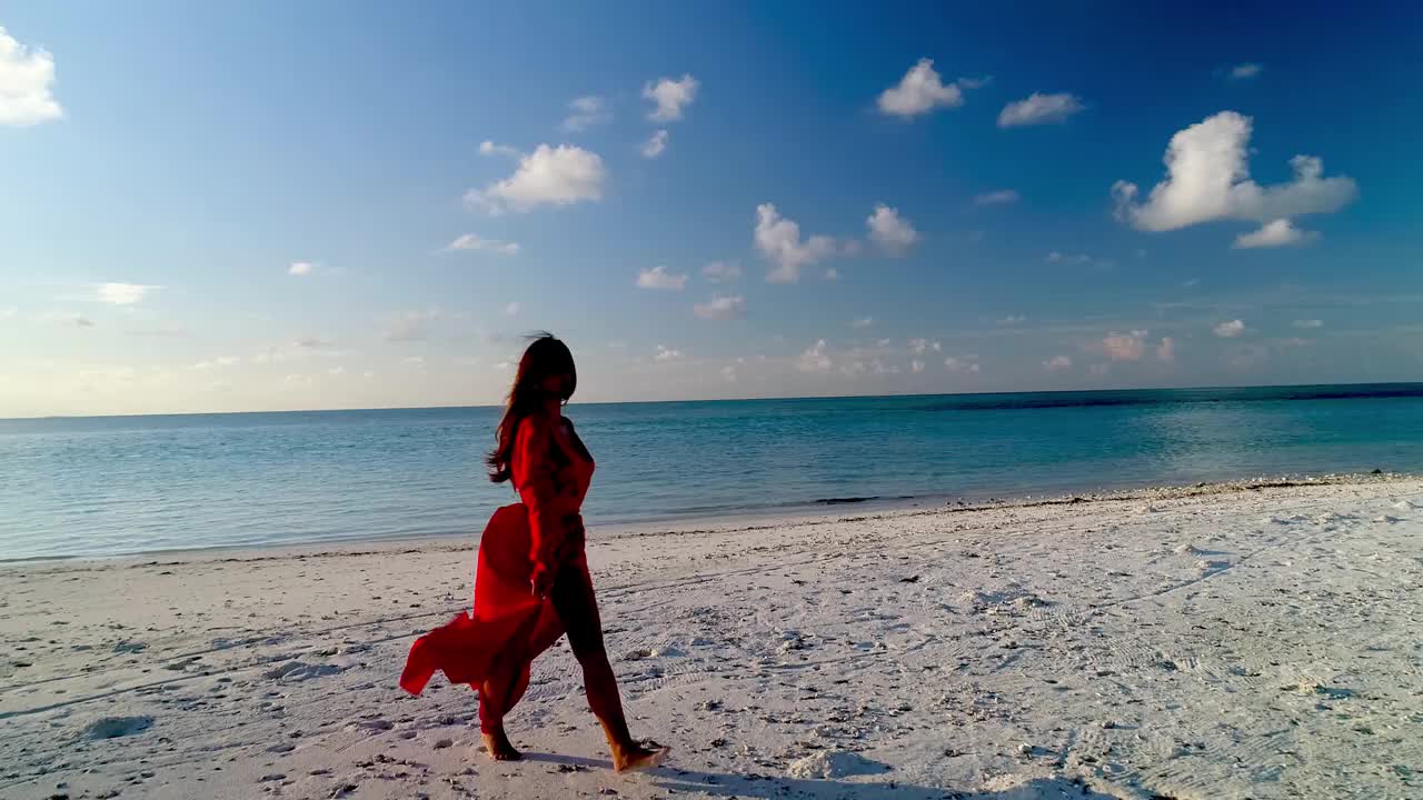 假期旅行的快乐年轻模特女孩在美丽的红色连衣裙走在海滩度假酒店度假。热带岛屿豪华海滩别墅。造型在马尔代夫视频下载