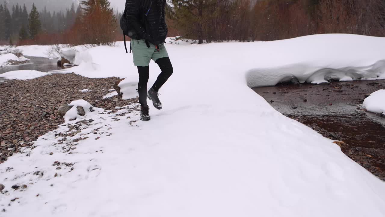 在暴风雪中，手冰凉的徒步旅行者蹲在摄像机前视频素材