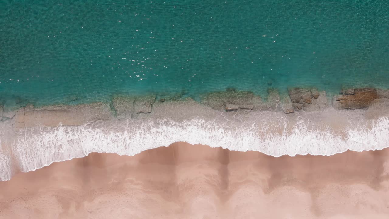 海浪冲击着沙滩。美丽的海岸线和热带海滩。海浪拍打着海滩，溅起白色的泡沫。自然美。海景视频素材