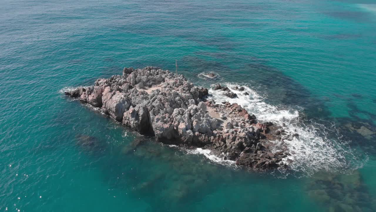 湛蓝的海洋与空石岩壁，无人机观看。大海的巨浪冲击着岩石的海崖。从上面拍摄的海景视频素材