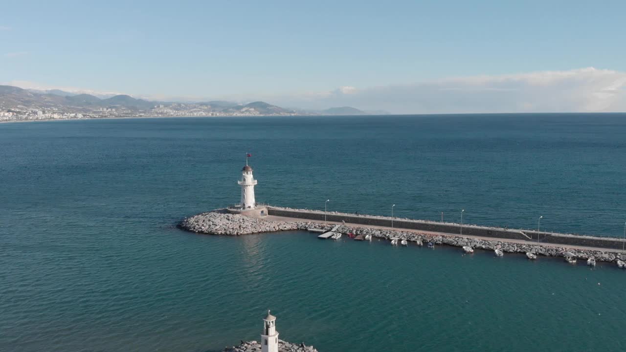 在海面风平浪静，天空晴朗的海边建造灯塔。海湾上的灯塔。土耳其的阿兰亚港视频素材