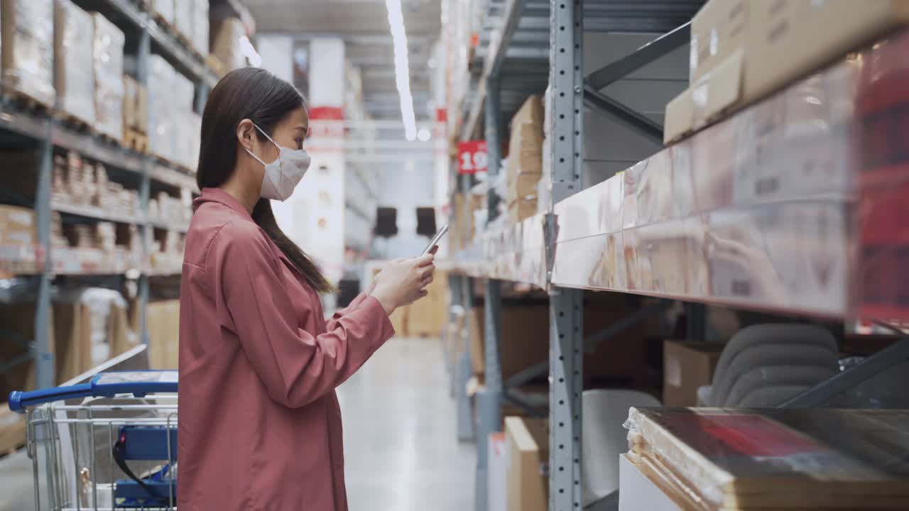 年轻的亚洲妇女戴着口罩在百货商店购物视频素材