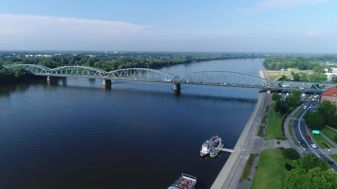 维斯瓦河上的桥在Toruń，车辆繁忙。从无人机拍摄的画面中可以看到一个晴朗的蓝天。视频素材