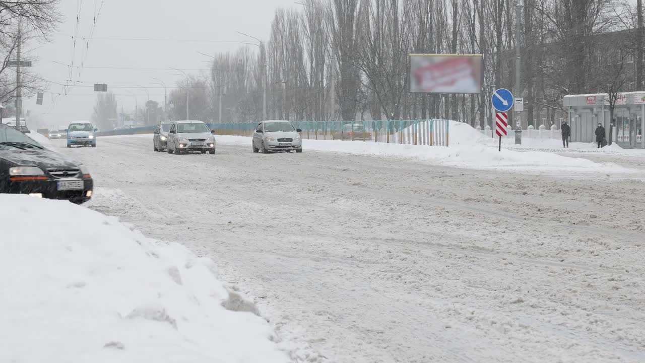 冬天下雪时城市道路上的汽车交通。视频素材