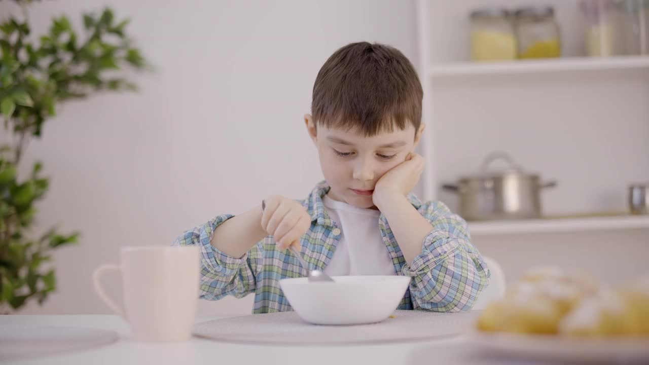 孩子难过的看着碗里，拒绝吃粥，养成健康的饮食习惯视频素材