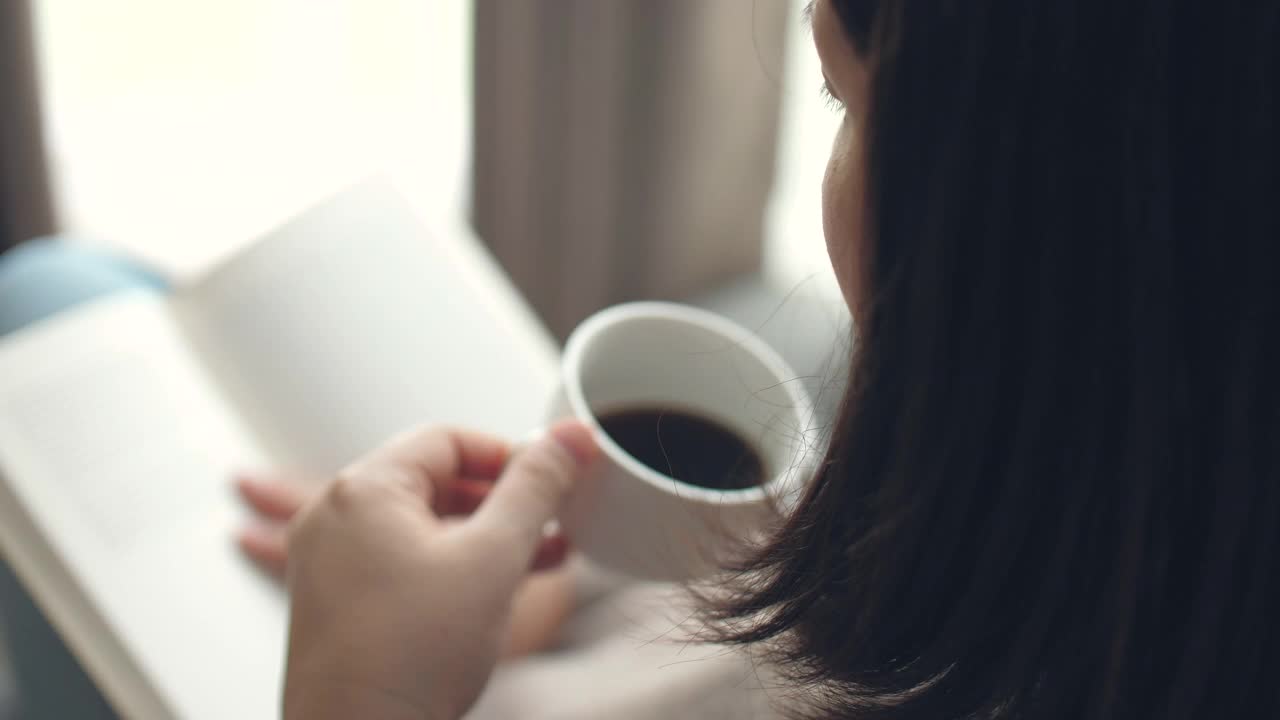 女人在家里放松的时候看书喝咖啡视频素材