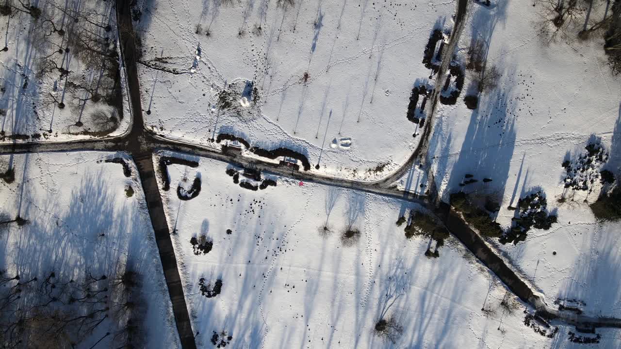 飞越冬季公园。摄像机是向下的。雪后的痕迹清晰可见。视频素材