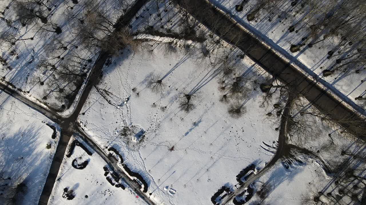 飞越冬季公园。摄像机是向下的。雪后的痕迹清晰可见视频素材