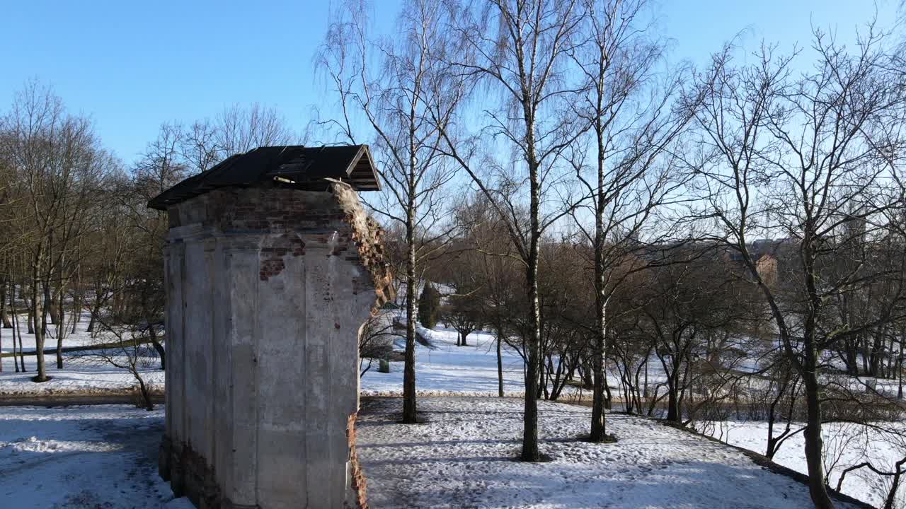 在冬季公园飞行。飞过旧建筑的废墟。无人机在废墟周围飞行。视频素材