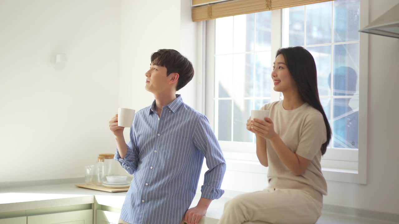 夫妇-年轻的男人和年轻的女人拿着杯子聊天视频素材