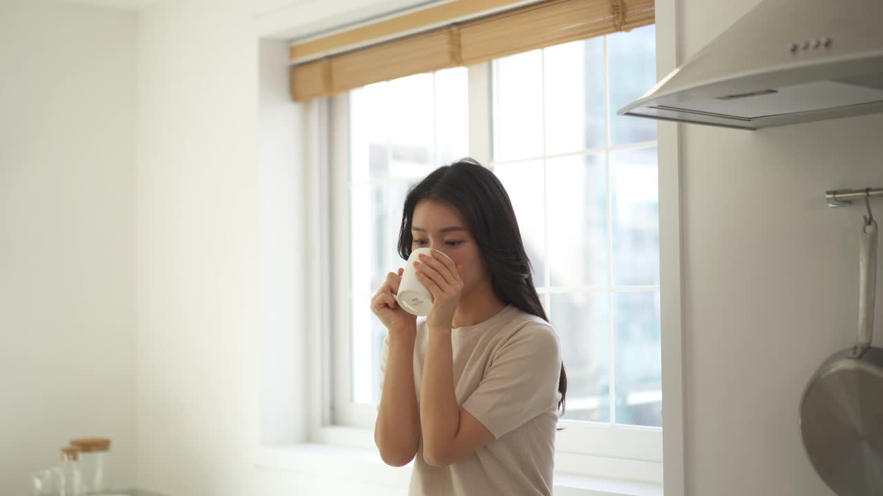 夫妇-年轻女子拿着一个杯子喝咖啡视频素材