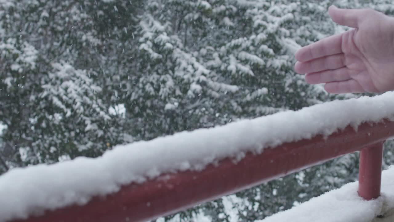 男人正在清扫阳台栏杆上的雪视频下载