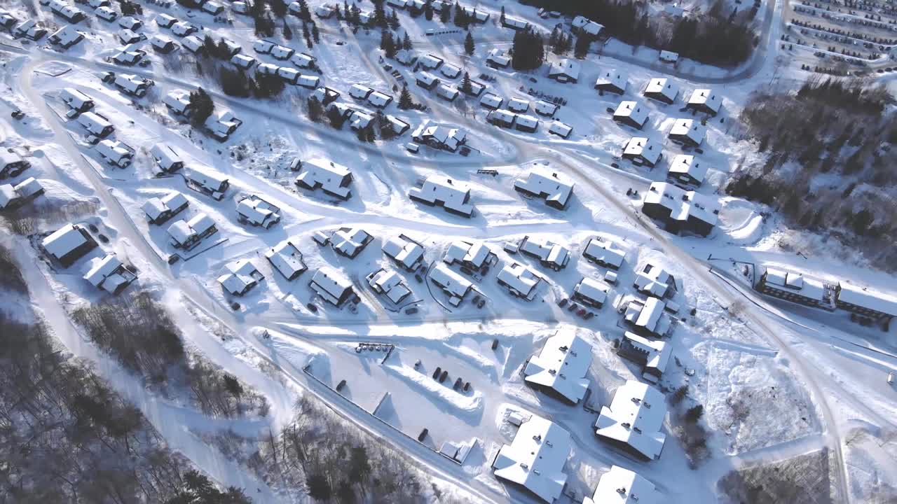 一个大型高山滑雪胜地的冬季度假小屋的航拍视频。视频素材