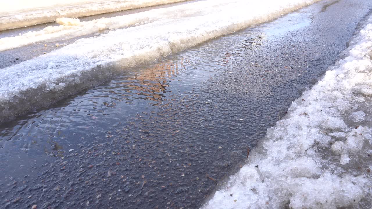 泉水沿着车辙流淌，积雪融化视频素材