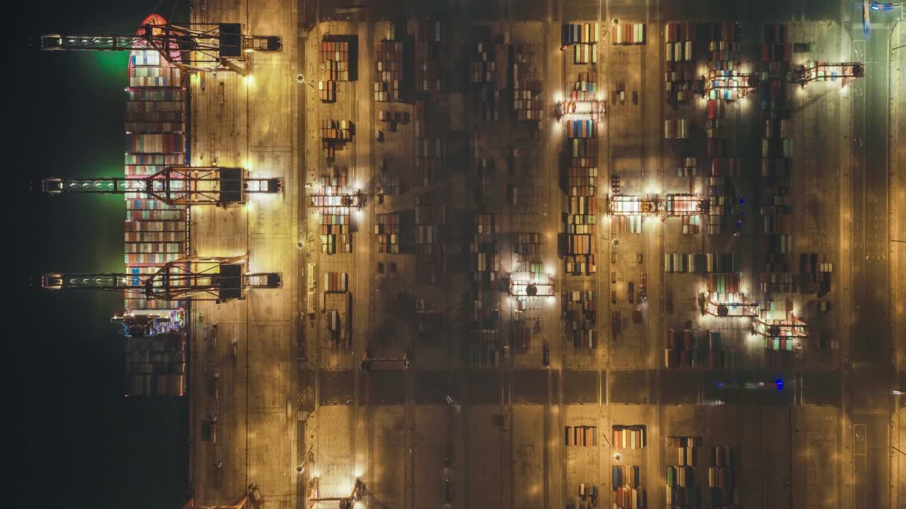 繁忙的工业港口，集装箱船在夜间鸟瞰图视频素材