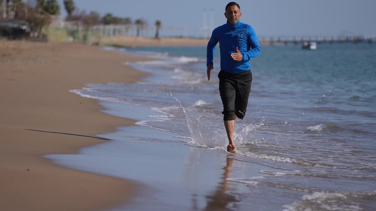 慢镜头男人在海滩上慢跑视频素材