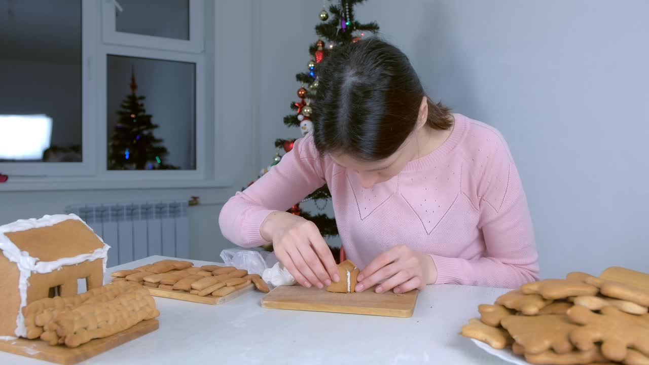 女人做姜饼的肖像，房子用糖霜粘合部分。视频素材